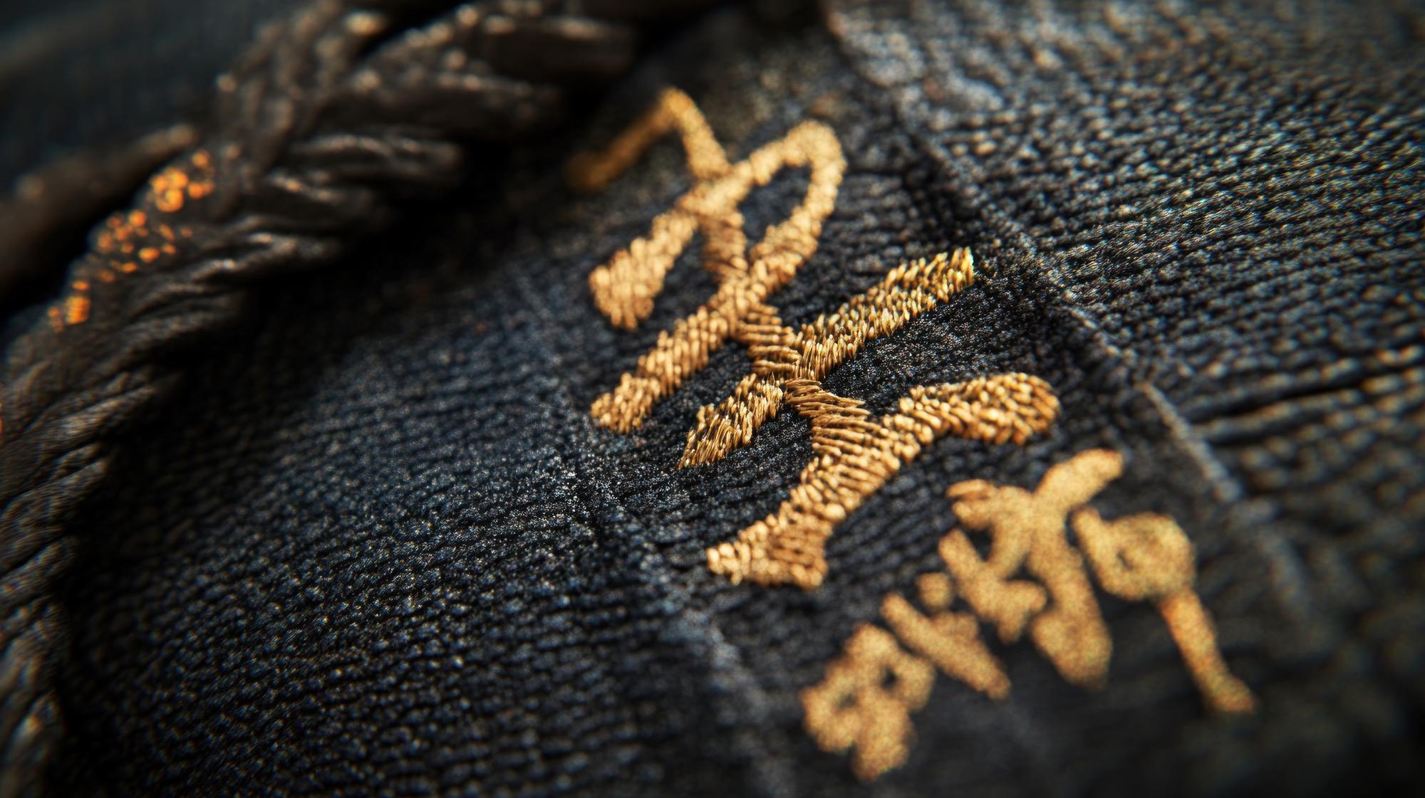 Close-up of luxury gold-thread embroidery on dark fabric